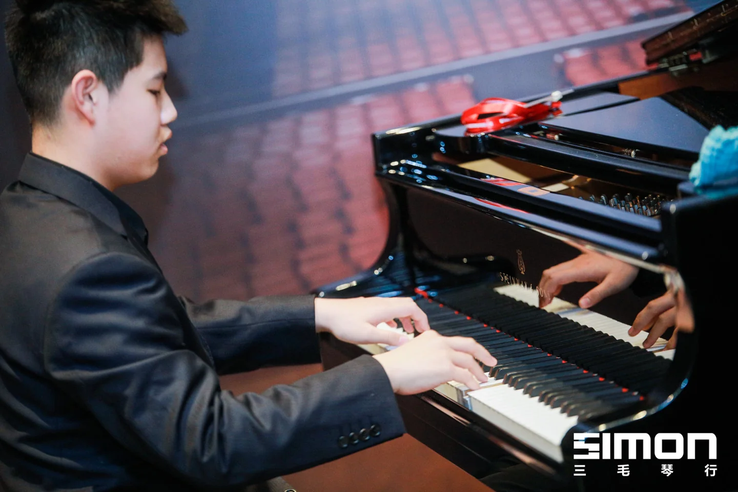 Lala focused on the keys of a grand piano